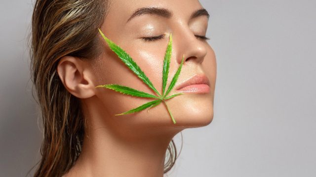 A woman with a hemp leaf resting on her face