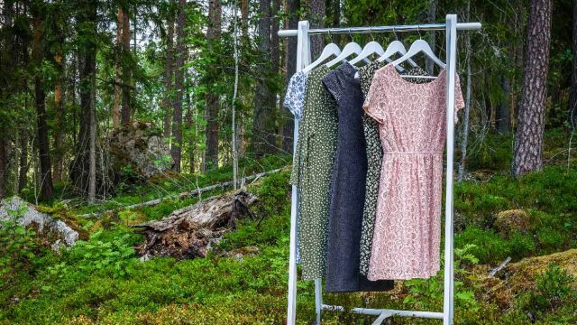 Sustainable women's apparel hanging on a rack in the woods