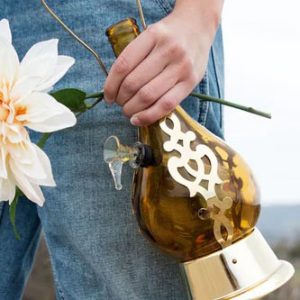 A person holding a decorative glass water pipe