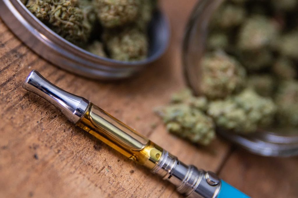 CBD vaporizer pen next to hemp flower