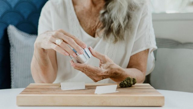 Woman using metal weed grinder