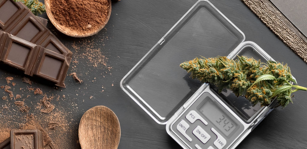 Cannabis flower buds placed in a glass dish on a digital scale, showing precise weight measurement.