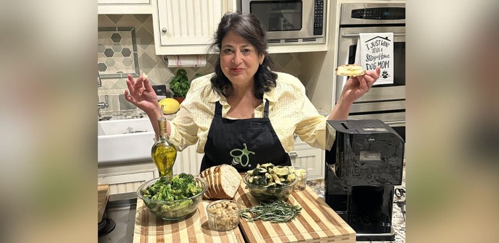 Maria Calabrese in her home kitchen using the LEVO II infuser to create a rosemary-garlic oil, showing how decarboxylators fit into everyday cooking.