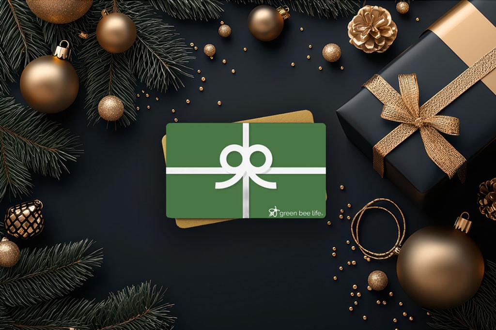 Green Bee Life gift card on a black background with golden Holiday decorations